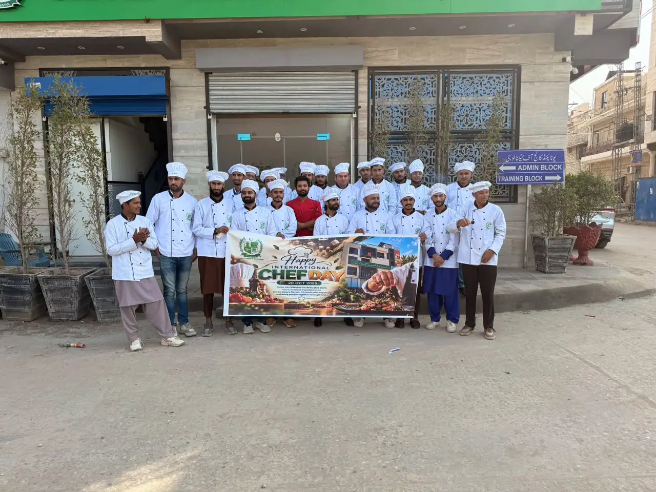 Culinary students with the International Chef Day banner outside the college