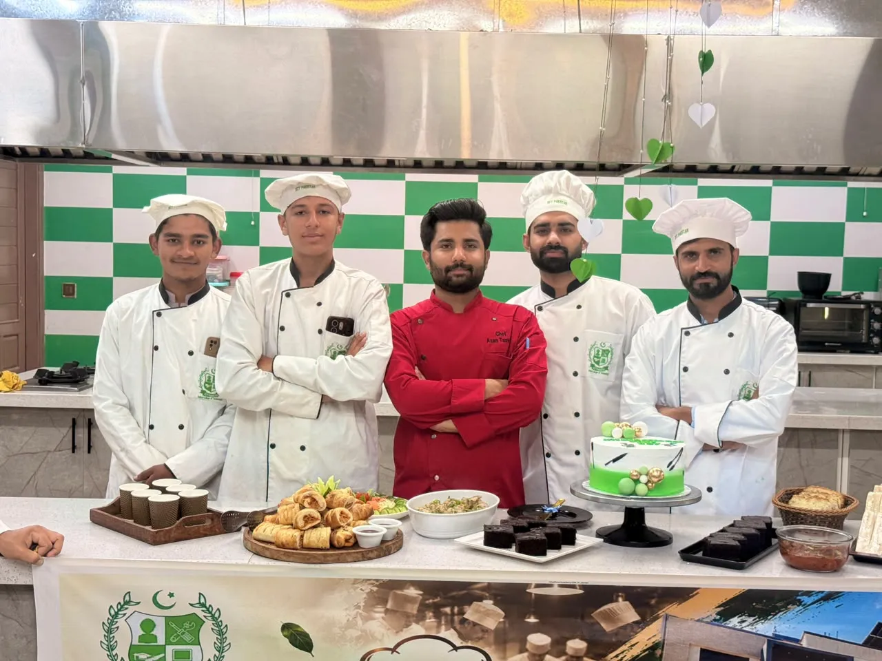Chef Azan Tanveer with students beside the celebration cake