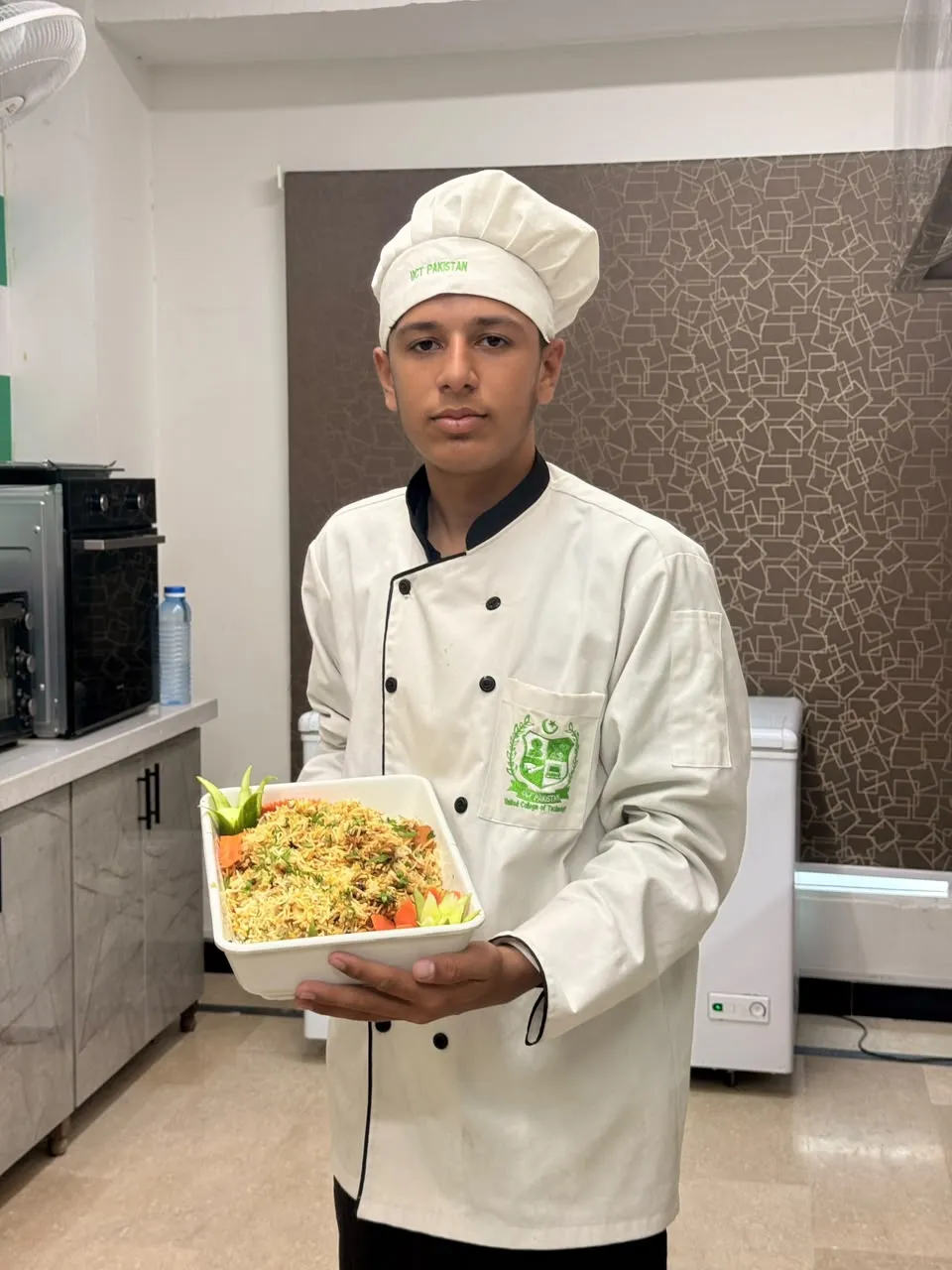 A culinary student presenting a rice dish on International Chef Day